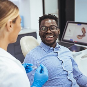 a smiling man speaking with his dentist