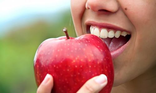 close up person eating apple