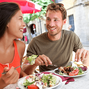 a man with dentures enjoying a meal with his partner
