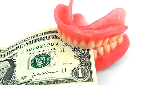 dentures biting money representing the cost of dentures in Vienna 