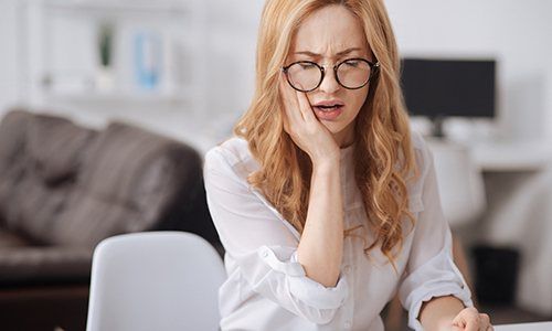 a woman suffering from tooth pain