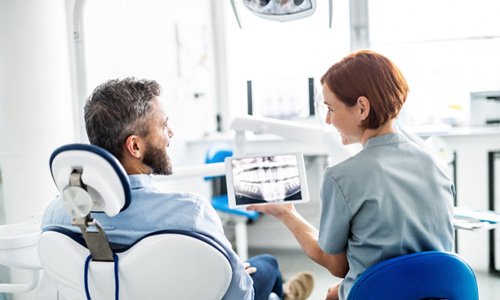 a dentist showing a patient his X-rays