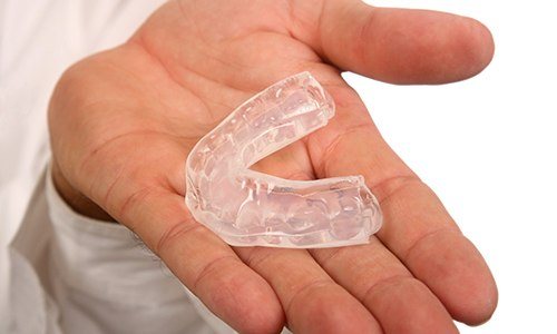 Hand holding a mouthguard