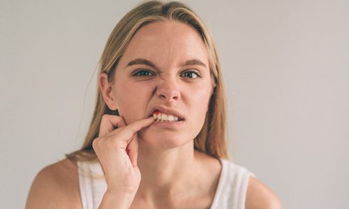 woman frowning showing red gums