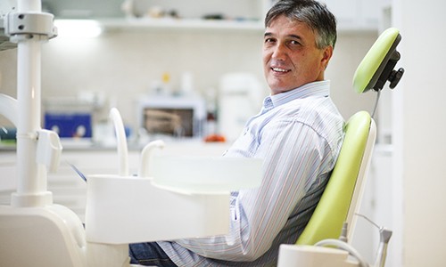 Man wearing collared shirt smiling in dental chair
