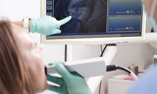 Patient and dentist looking at intraoral photos