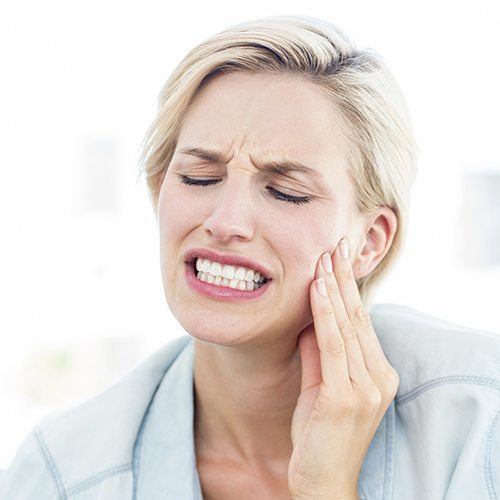 Woman holding cheek in pain