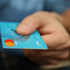 Man extending hand holding debit card