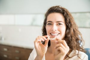 Woman using Invisalign on her top teeth